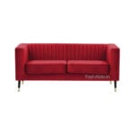 The Sana Velvet 2 Seater Tuxedo Sofa 56 is a stylish red velvet sofa with vertical stitching on the backrest, two seat cushions, and slender metal legs, set against a white background.