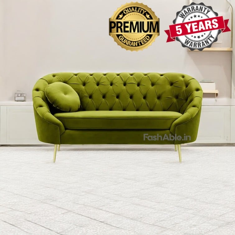 A stylish green tufted sofa with a round cushion graces a room featuring a light-colored floor, inviting you to explore its comfort. Above it, badges proudly display Premium Quality Guaranteed and 5 Years Warranty, echoing the craftsmanship you can shop for now.