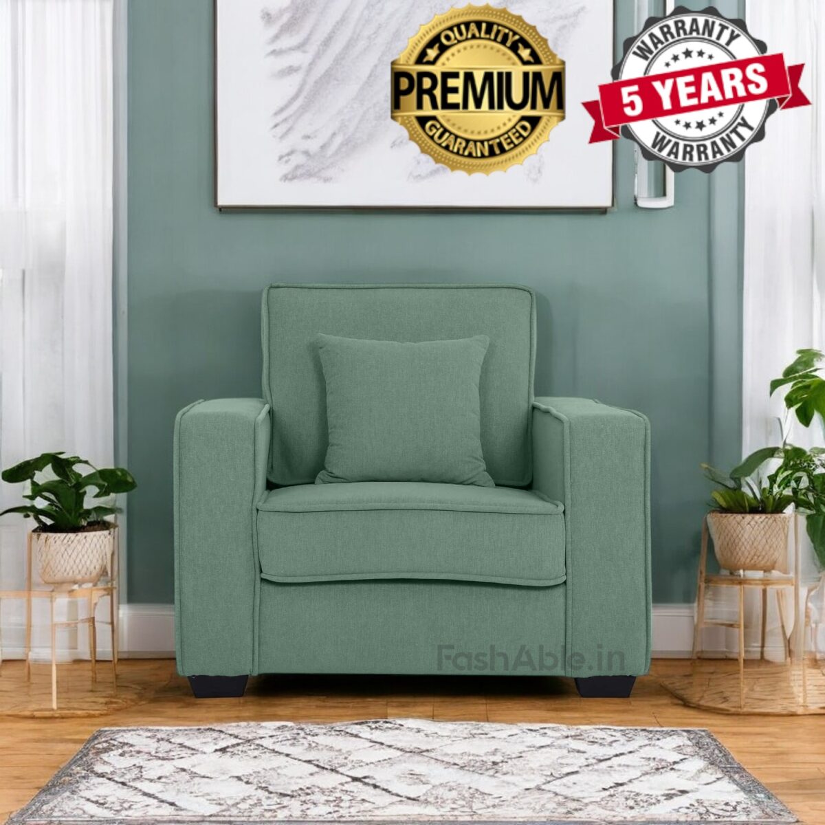 Explore the elegance of a green armchair in a living room with a wooden floor and patterned rug. Small plants flank the chair, while framed artwork adorns the wall above. With Premium Quality Guaranteed and 5 Years Warranty badges, this piece is fashable for any modern home in India.