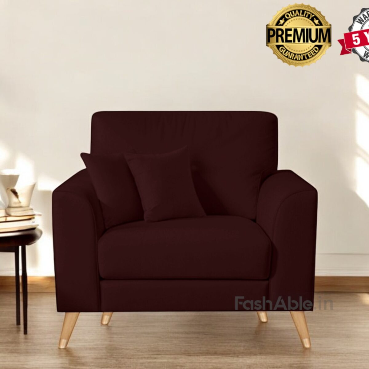 A deep brown armchair with wooden legs graces the bright room, inviting you to explore its comfort. It comes with matching cushions, a small table stacked with books, and a mug. The Premium Quality and 5 Years Warranty badges assure you its a stylish purchase from Fashable.
