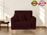 A deep brown armchair with wooden legs graces the bright room, inviting you to explore its comfort. It comes with matching cushions, a small table stacked with books, and a mug. The Premium Quality and 5 Years Warranty badges assure you its a stylish purchase from Fashable.