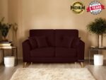 A cozy living room with a dark brown sofa adorned with two cushions invites you to explore its charm. The room features two potted plants, stacked books on a small table, and a beige rug. Banners proudly showcase Premium Quality and a 5 Years Warranty, enticing you to buy.